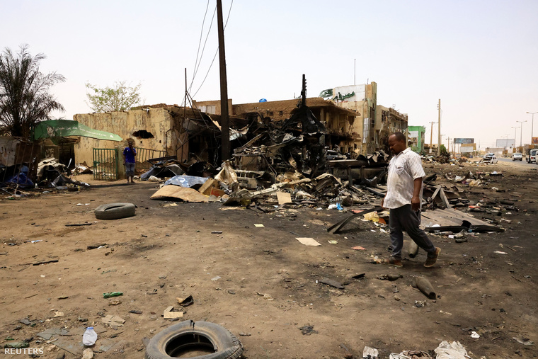 Rommá lőtt épület mellett sétál el egy férfi a szudáni fővárosban, 2023