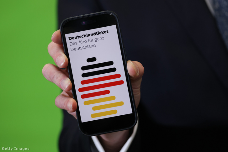 Volker Wissing német közlekedési miniszter a Deutschland-Ticket alkalmazást mutatja egy telefonon 2023. április 25-én