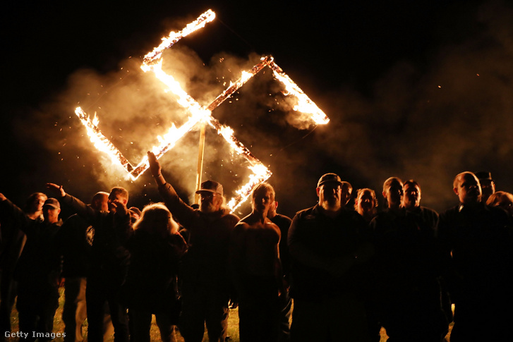 Az Egyesült Államok egyik legnagyobb neonáci csoportjának, a Nemzeti Szocialista Mozgalomnak a tagjai egy égő horogkeresztet tartanak egy gyűlés után 2018. április 21-én Georgia államban