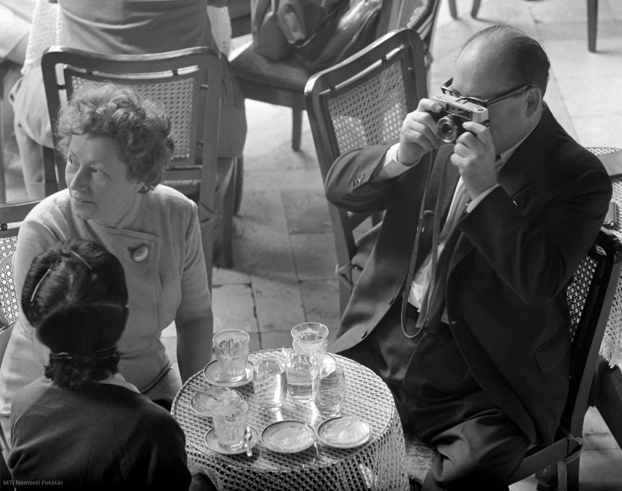 Budapest, 1964. augusztus 11. Asztaltársait fényképezi egy vendég a hetvenéves New York-palotában működő Hungária Kávéházban