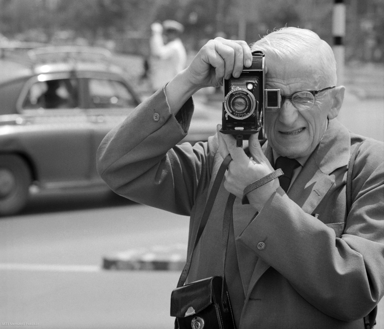 Budapest, 1965. július 8. Idős férfi egy régi kihúzatos, középformátumú fényképezőgéppel fényképez a fővárosi utcán