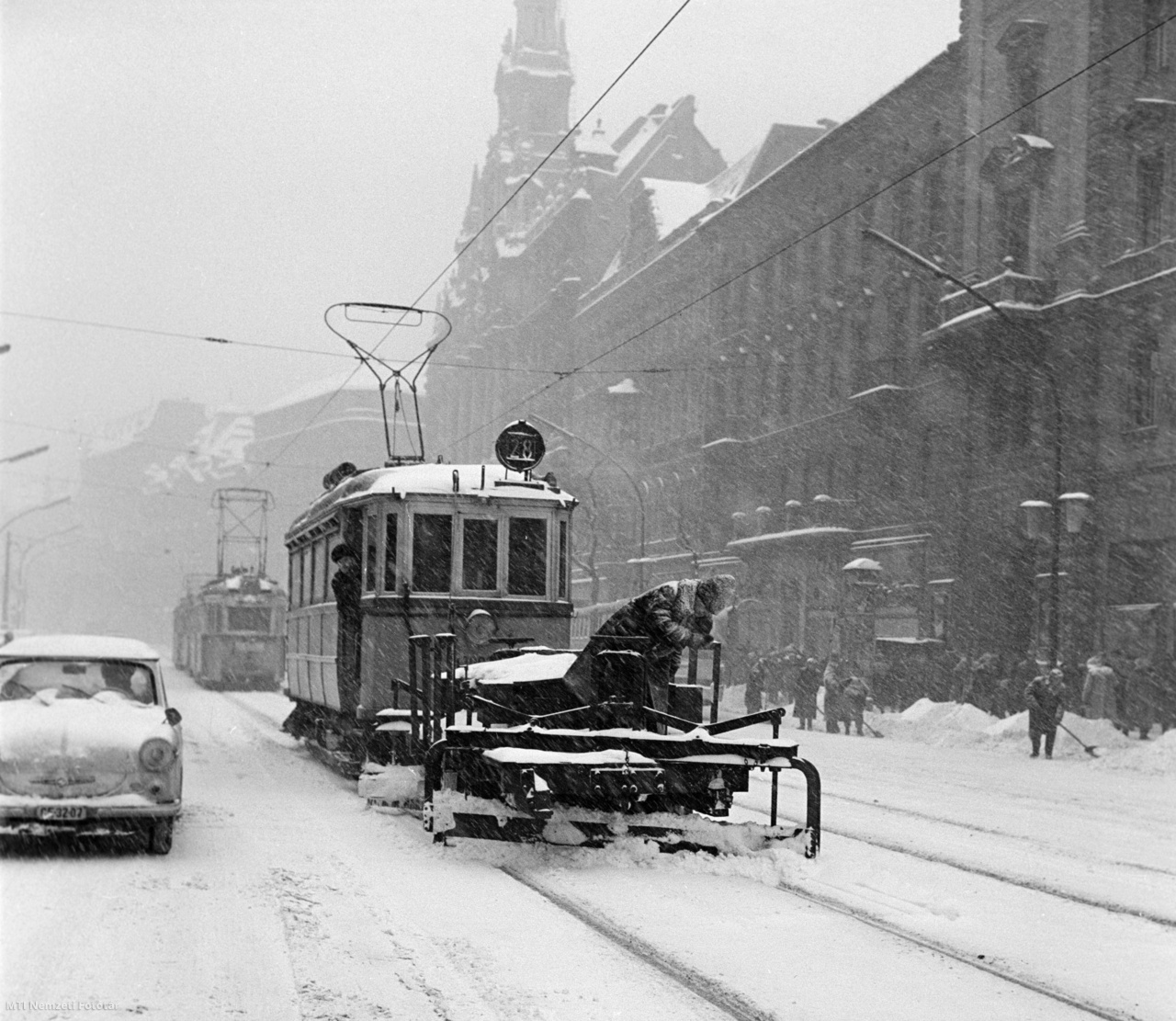 Budapest, 1963. február 3. A Fővárosi Villamos Vasút Községi Vállalat (FVKV) speciális villamos motorkocsi elé rögzített kotrólapátjával tisztítják meg a villamospályát és a síneket a Lenin körúton (1990-től Erzsébet körút). A főváros egész területére óriási tömegű hó hullott, melynek eltakarítását megkezdte a Fővárosi Köztisztasági Hivatal a főútvonalakon.