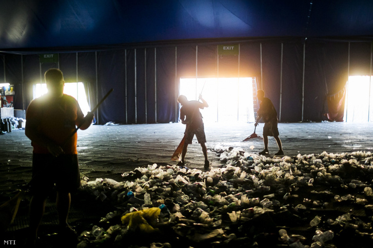 Összetakarítják a szemetet a Sziget Fesztivál A38 színpadjánál 2013. augusztus 12-én