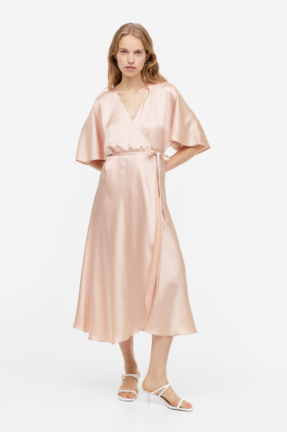 A H&M halványrózsaszín szaténruhája nagyon nőies és elegáns, ráadásul szépen kiemeli a derekat is. 16 995 forintért vásárolhatod meg.