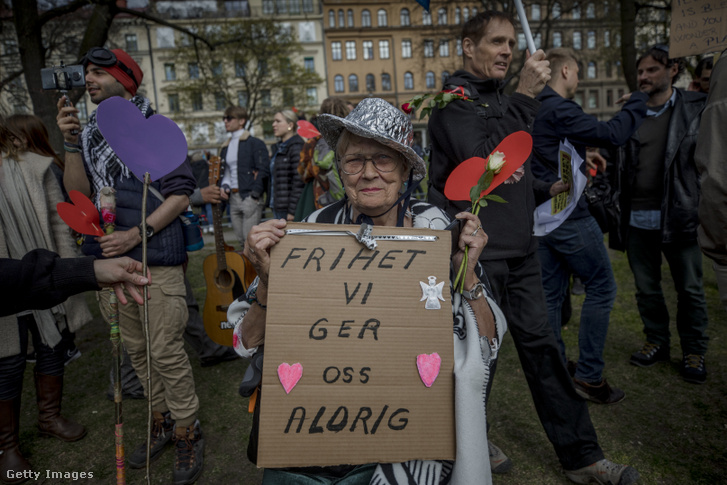Idős hölgy sikkes alufólia kalapban a Covid-19 járvány miatt bevezetett kijárási korlátozások elleni illegális tüntetésen Stockholmban, Svédországban 2021 májusában