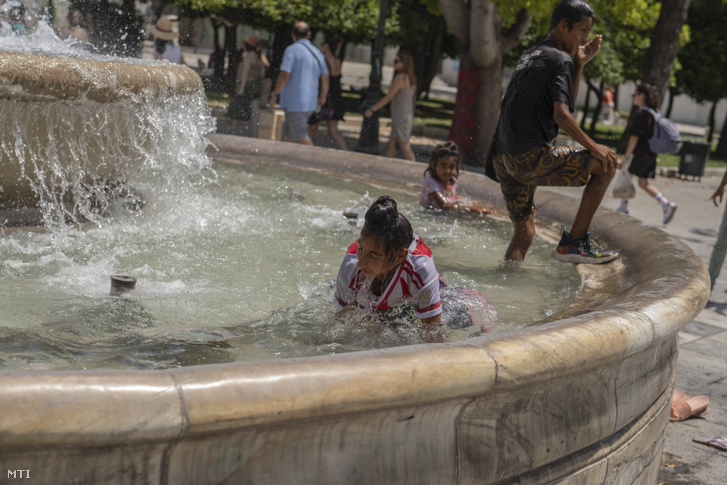 Szökőkút vizében hűsölnek gyermekek az athéni Szintagma téren 2023. július 14-én