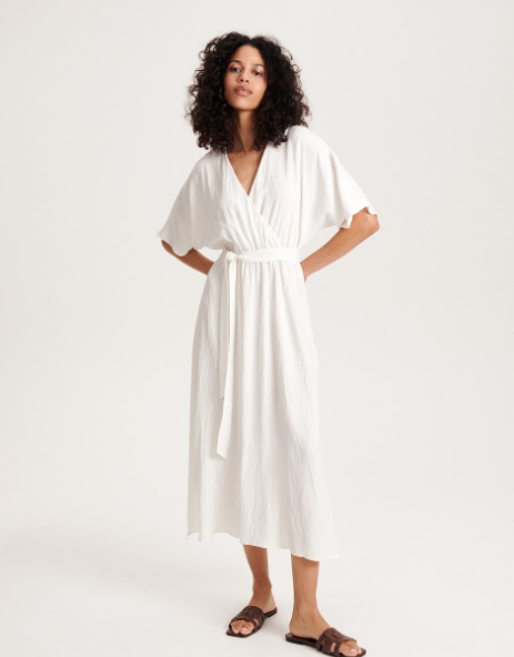 Egy fehér ruha mindig szuper a tűző napsütésben, ez az átlapolós mididarab pedig kényelmes, nőies, és karcsúsítja a derekat. 13 995 forint a Reservedben.