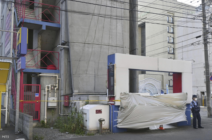Egy rendőr áll egy szállodaépületnél a Japán északi részén fekvő Szapporo város szórakozónegyedében, miután a rendőrség egy 62 éves férfi lefejezett meztelen holttestére bukkant a hotel egyik fürdőszobájában 2023. július 8-án