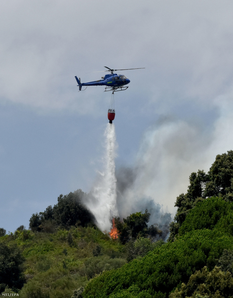 Helikopterről ledobott tűzgátló anyaggal próbálják megfékezni a lángokat a Szicília régióban fekvő Pedarában 2023