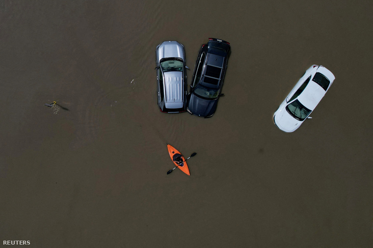Egy kenuban ülő személy elhalad a nemrégiben lezúdult esőzések árvize által részben elöntött autók mellett az egyesült államokbeli Montpelier-ben 2023