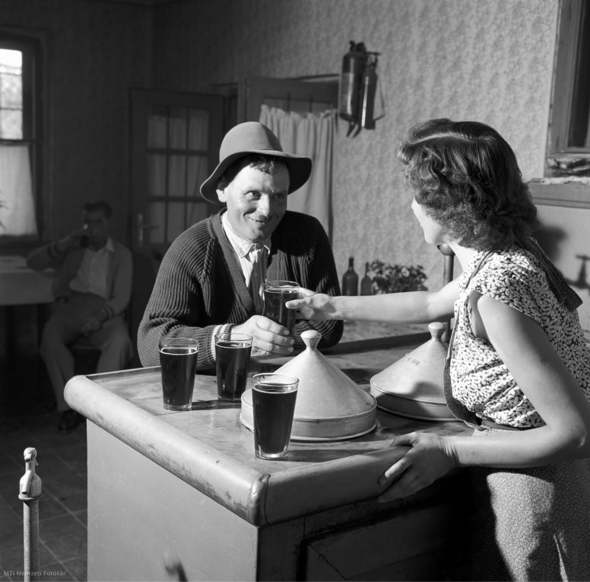 Bogyiszló, 1958. augusztus 17. Kocsmárosnő kiszolgál egy vendéget vörösborral a Gógai (Kutyatanyai) révészcsárdában