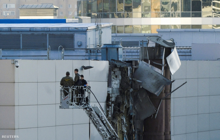 Nyomozók dolgoznak egy megrongálódott tető közelében egy ukrán dróntámadást követően Moszkvában 2023. augusztus 18-án