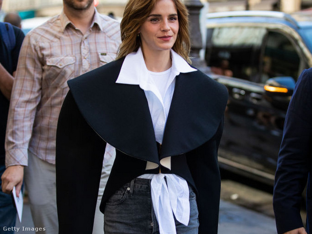 Emma Watson öltözéke itt egyszerre homokóra sziluettű, fehér inges, fekete kabátos és nagy sálgalléros