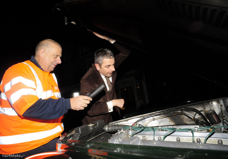 Rowan Atkinson a kigyulladt Jaguar MK7-et vizsgálja. (Fotó: Xposurephotos.com / Northfoto)