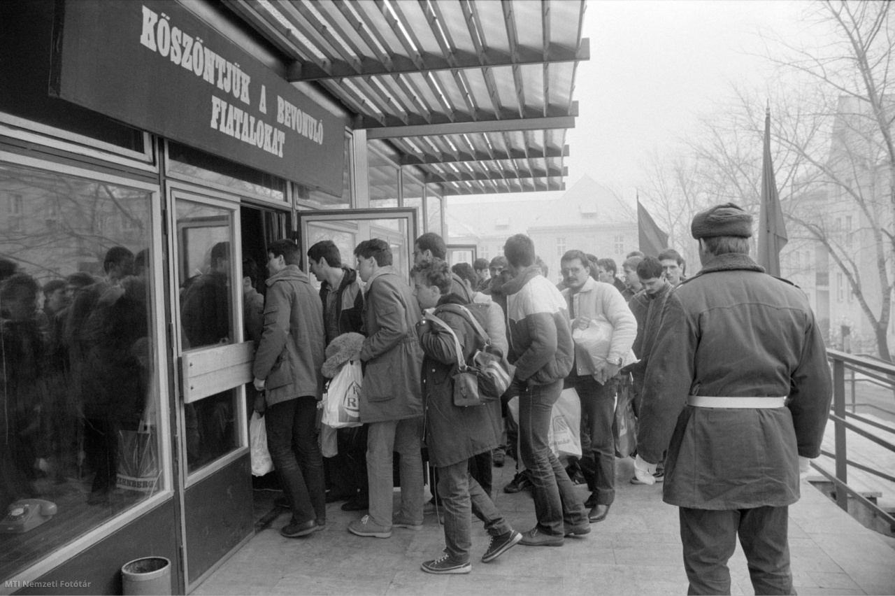 Budapest, 1985. február 28. Sorkatonai szolgálatra bevonuló fiatalok érkeznek a sorozás helyszínére. Az előtérben egy gyakorlóruhás katonai rendész (VÁP-os).
