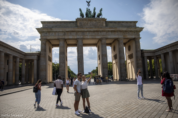 Turisták állnak a Brandenburgi kapunál Berlinben
