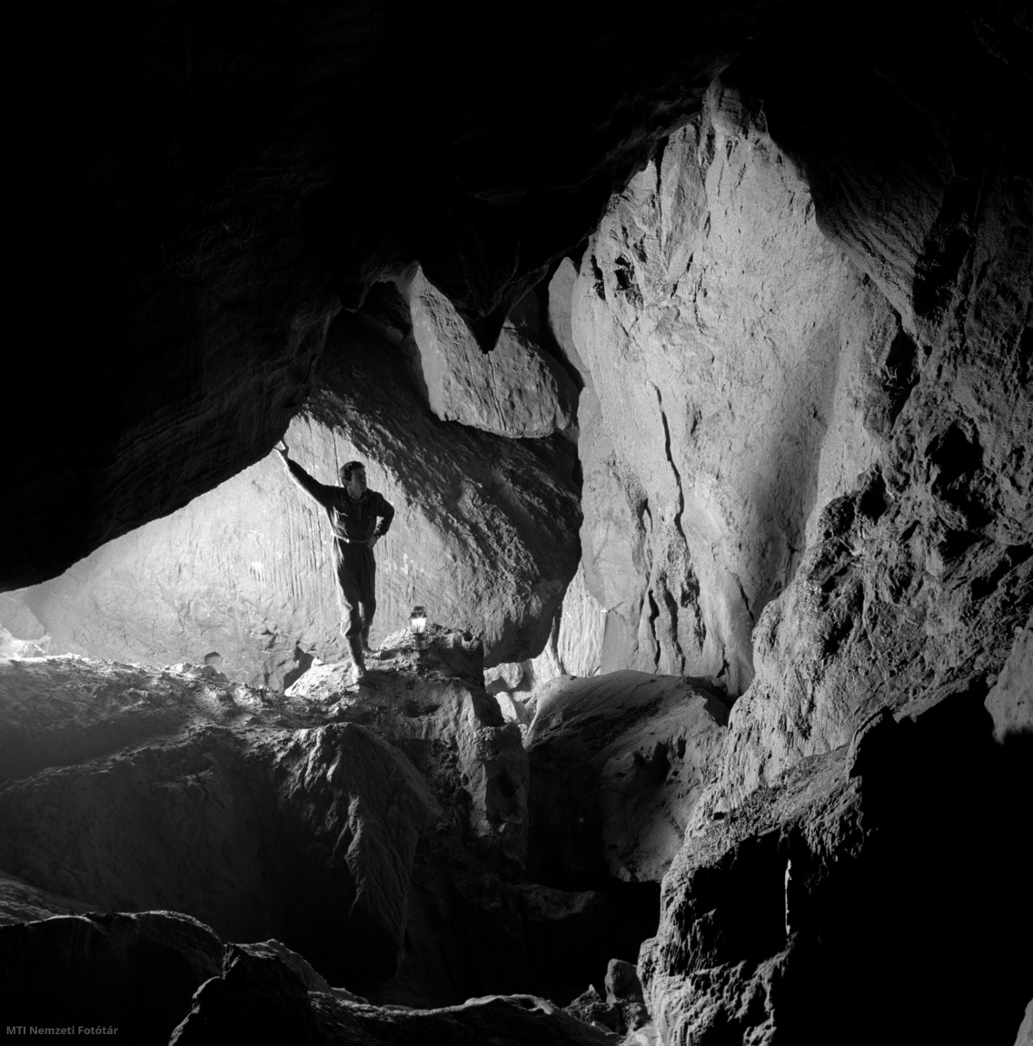 Aggtelek, 1964. december 11. Fotóriporter a Béke-barlang omladéktermének felső részén, amelynek boltozatáról egykor leszakadt több száz tonnás sziklák közti útvesztőben még a tapasztalt barlangkutatók is eltévedhetnek. A mészkőhegyek belsejében húzódó barlangokat bátor barlangkutatók tárják fel. Munkájuk eredménye: a nemzetközileg ismert aggteleki barlangvidék, ahol ma már öt nagy barlangot tartunk számon. A barlang klímája kitűnő, gyógyhatással van az asztmás betegekre, akik az új úton át pár hónap múlva már könnyűszerrel elérhetik az eddig teljesen járhatatlan folyosókat
