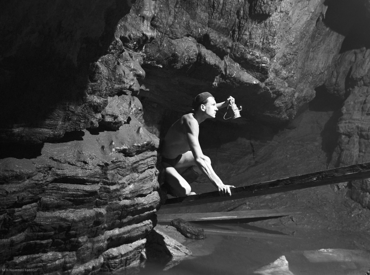 Orfű, 1960. augusztus 18. Hufnágel István egy pallón halad át a barlangban lévő víz fölött. A bányatechnikus a Baranya Intéző Bizottság barlangkutató csoportja tagjaként az orfűi karsztforrás föld alatti patak- és barlangrendszerét kutatja