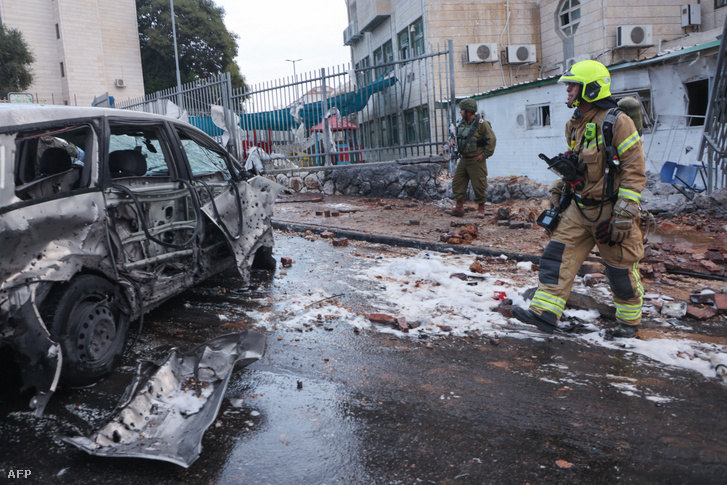 Izraeli rendőrök és mentőalakulatok átvizsgálják a Gázából indított rakétatámadás helyszínét 2023. október 9-én
