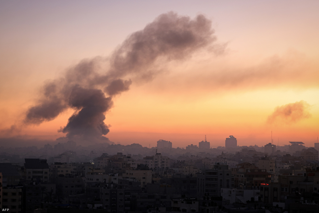 Tűz és füst emelkedik az épületek fölé Gáza városában egy izraeli légicsapás közben 2023. október 13-án