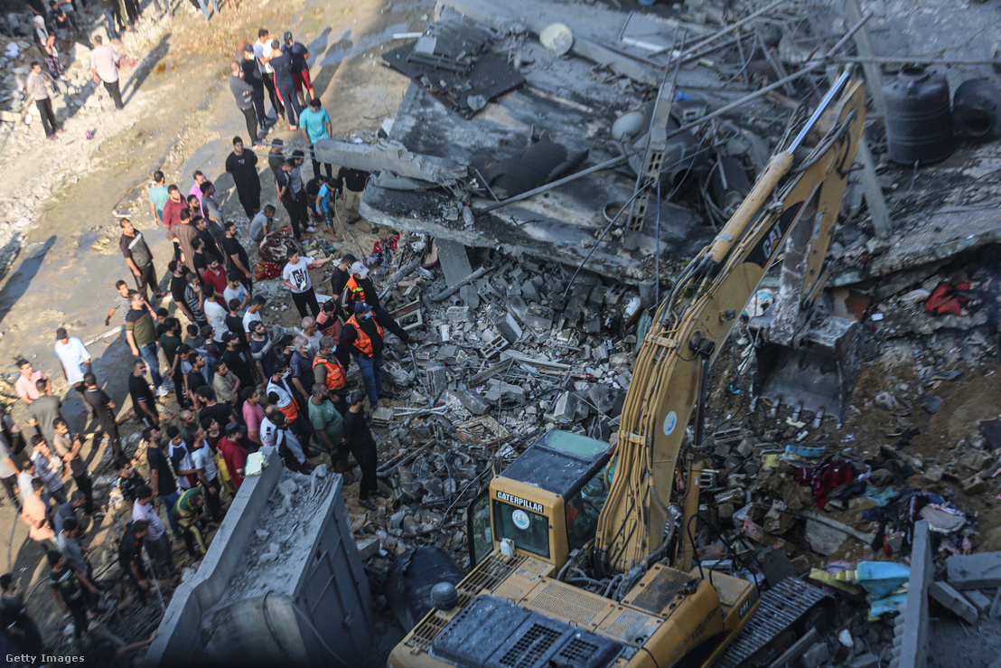 Polgári védelmi csapatok és lakosok kereső- és mentőakciót indítanak a lerombolt vagy súlyosan megrongálódott épületek körül Han Juniszban 2023. október 14-én
