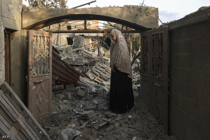 Egy nő megvizsgálja az otthonában keletkezett károkat a Gázai övezet déli részén lévő rafahi tábor elleni izraeli csapások után 2023. október 14-én