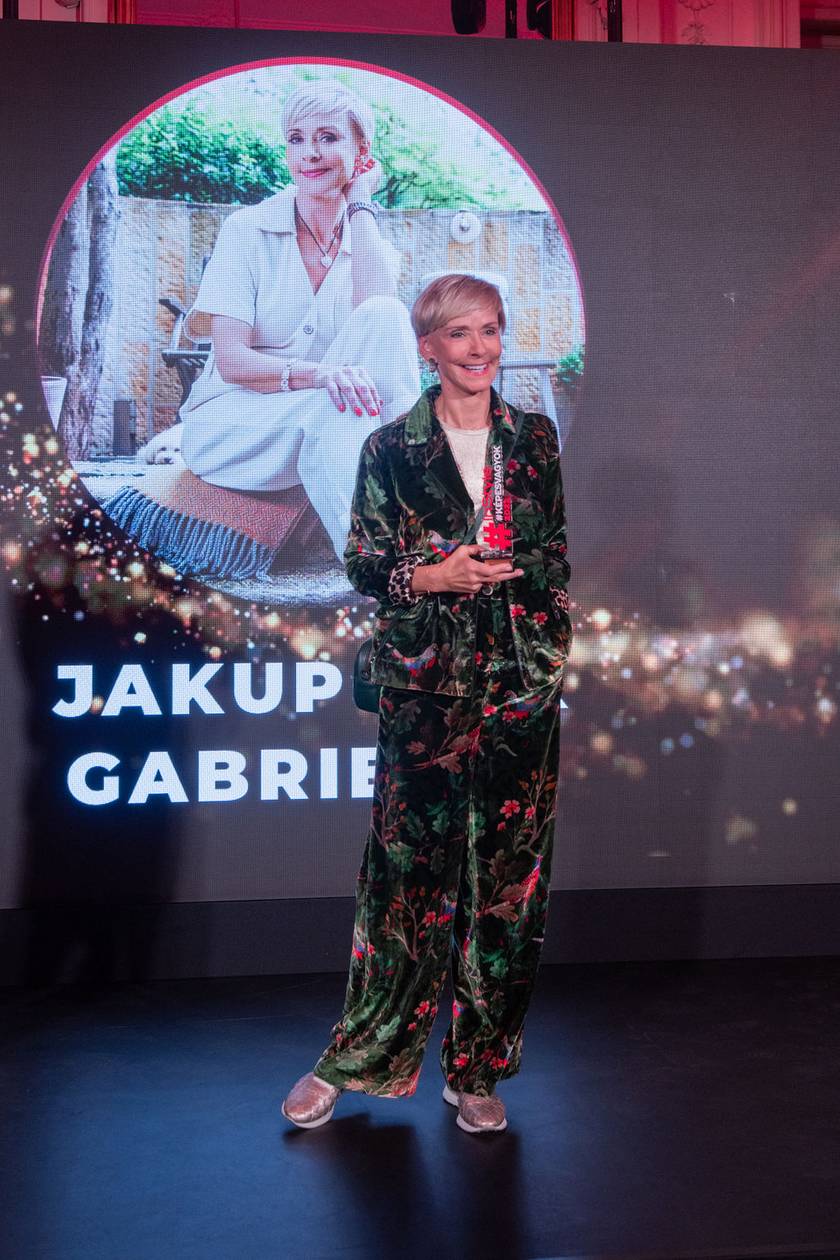 Jakupcsek Gabriella mindig is híres volt egyedi, vagány öltözködési stílusáról. Hatvanévesen egy mintás, bársonyból készült nadrág-blézer összeállításban és csillogó sportcipőben vette át díját.