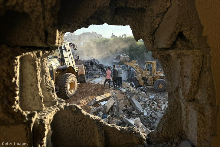 A polgári védelem tagjai és lakosok keresési és mentési műveletet végeznek a romok és a lerombolt épületek között Gázában 2023. október 15-én