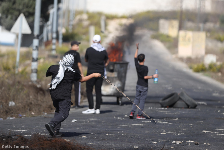 Az izraeli erők golyókkal, gumilövedékekkel és könnygázzal avatkoznak be a tüntetésekbe, amikor palesztinok egy csoportja a Beit El katonai ellenőrzőpont közelében gyűlik össze, hogy tiltakozzon az izraeli támadások ellen a ciszjordániai Rámalláhban 2023. október 16-án