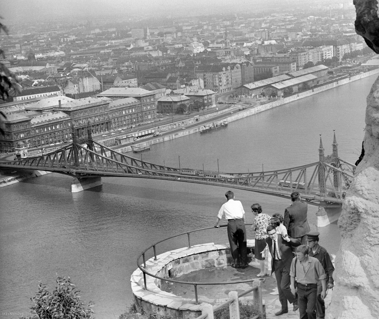Budapest, 1964. július 20. Nézelődők a Gellért-hegy egyik kilátóteraszáról. Előtérben a Duna folyó és a Szabadság híd, mögötte a Marx Károly Közgazdaságtudományi Egyetem, a Közraktárak és Ferencváros lakóházai