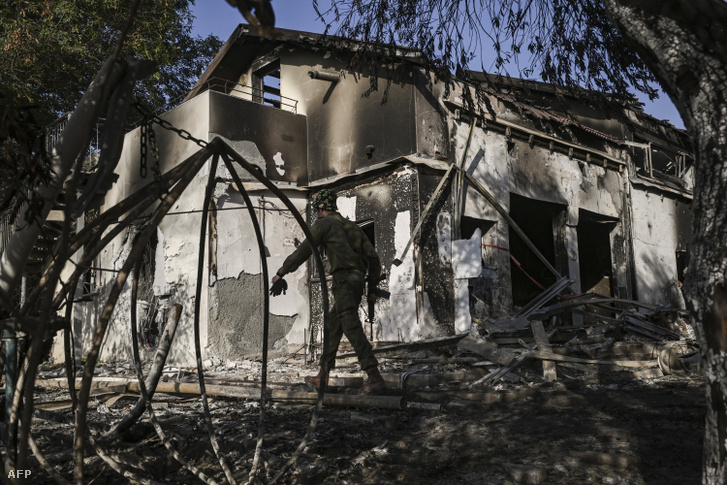 Egy izraeli katona járőrözik egy megrongálódott ház közelében a Gázai övezet határához közeli Kibutz Beeriben 2023. október 25-én