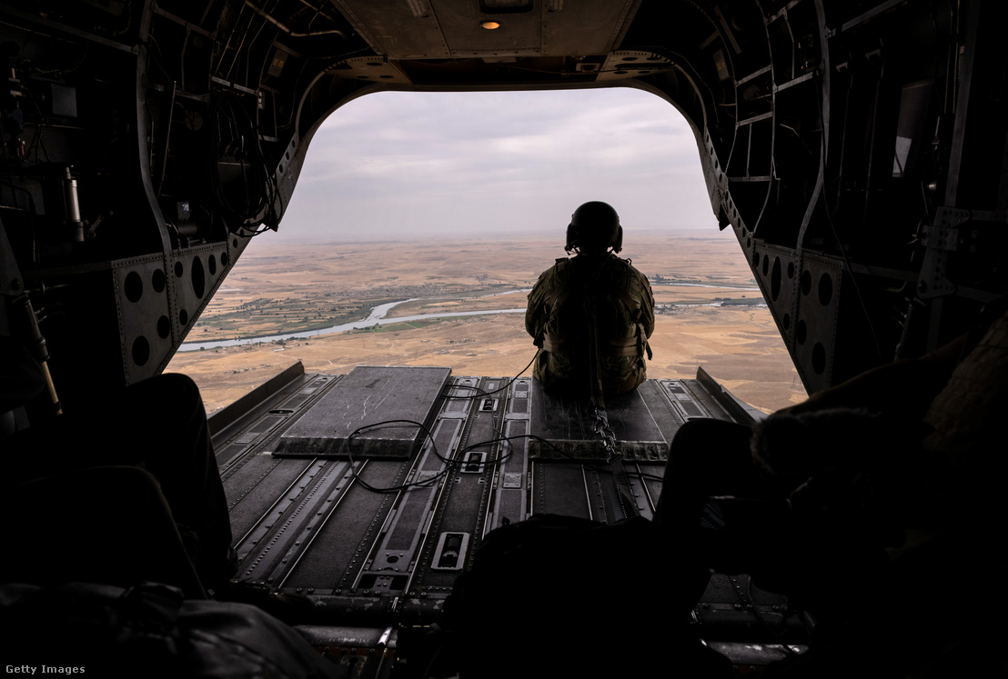 Az amerikai hadsereg helikopterszemélyzetének tagja kinéz egy CH-47 Chinook helikopter nyitott rámpájáról, miközben csapatokat szállít 2021. május 24-én Északkelet-Szíria felett