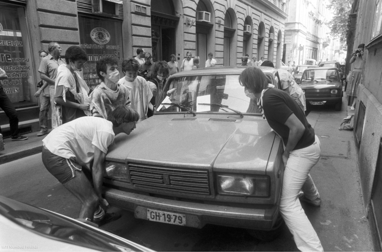 Budapest, 1990. június 27. A Piknik 2000 környezetvédő csoport aktivistái egy járdán parkoló autót emelnek vissza az úttestre Budapesten, a Magyar utcában