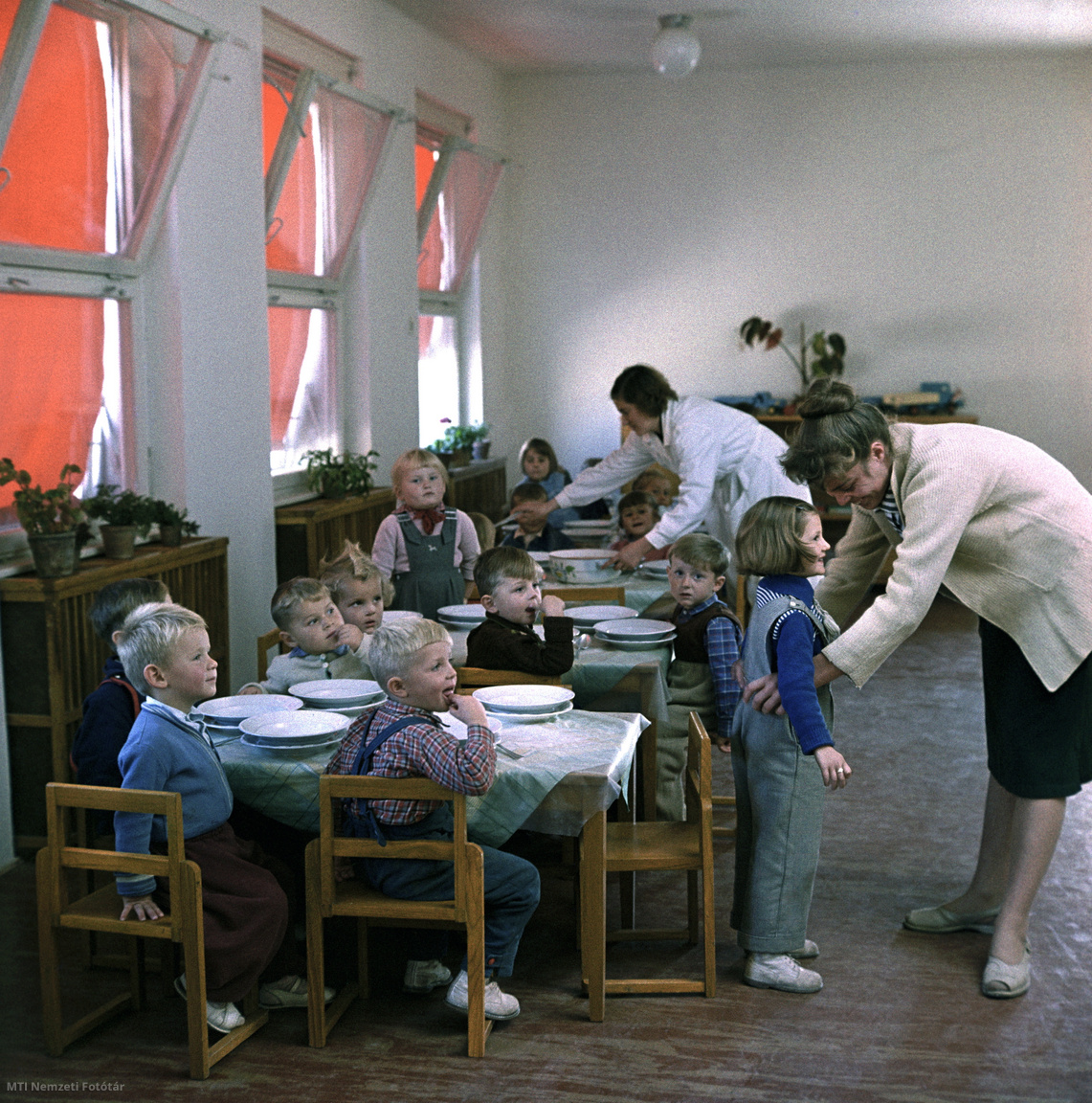 Sztálinváros, 1959. október 17. Ebédosztás a sztálinvárosi Maximenkó közi óvodában: a gyermekek az asztalnál ülve várják az ebédet, a hátsó asztalnál egy dolgozó levest mer a tányérokba