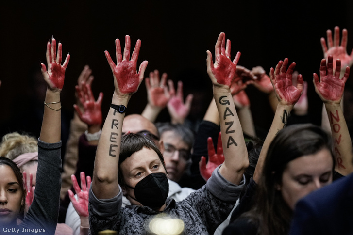 A gázai tűzszünetet követelő tüntetők vörösre festett kezüket emelik fel 2023. október 31-én Washington DC-ben
