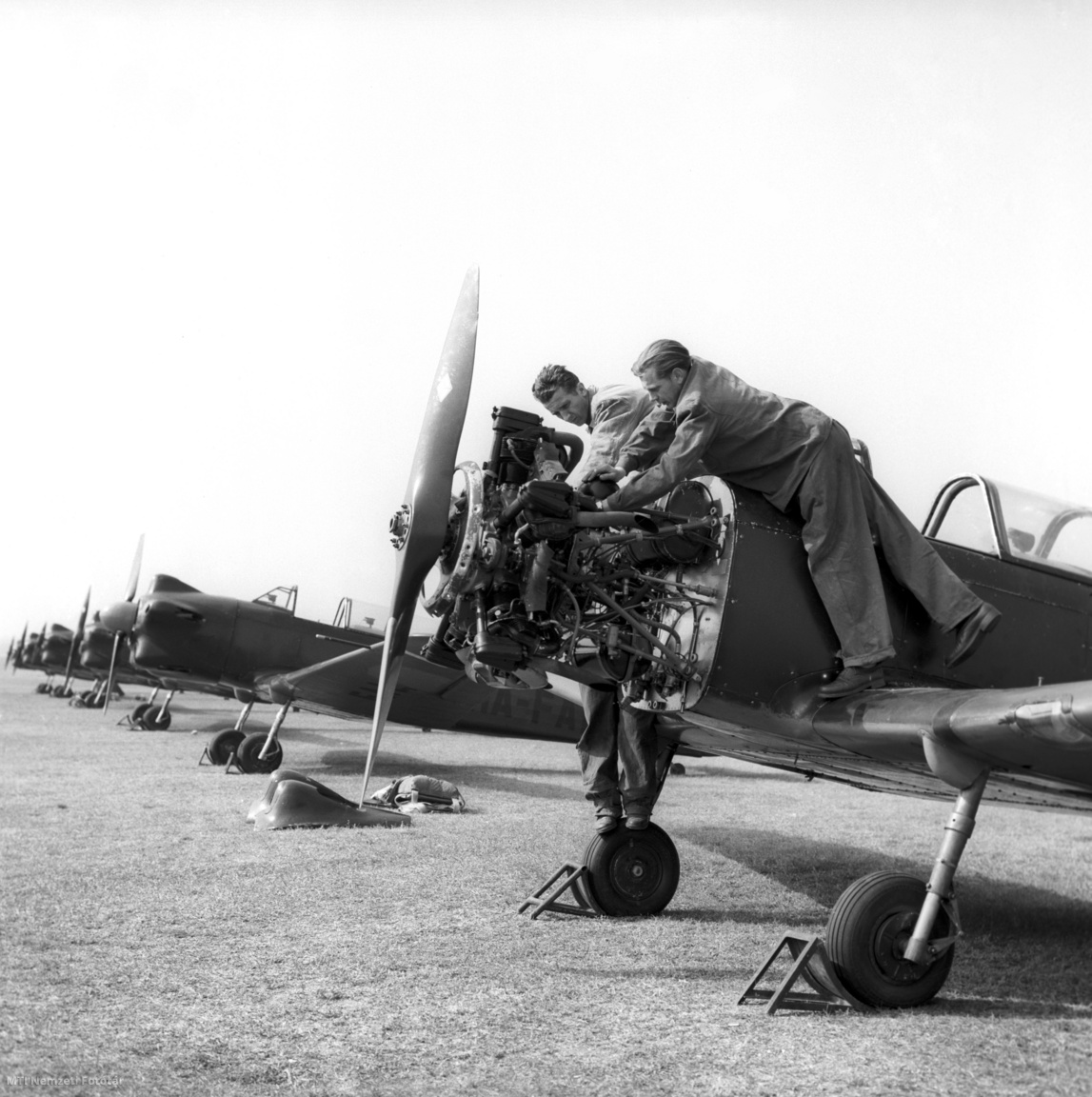 Dunakeszi, 1959. április 3.  Indulás előtt motorszerelők vizsgálják át az egyik versenyző gépét  az alagi reptéren, a Magyar Honvédelmi Sportszövetség és a Magyar Népköztársaság Központi Repülőklubja április 4-e tiszteletére rendezett repülőversenyén.