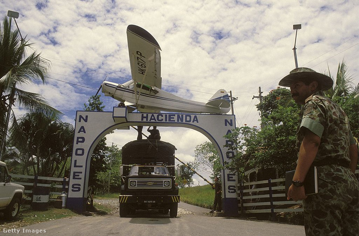 Kolumbiai katonák elfoglalják a „Hacienda Nápoles”-t, a Medellín-kartell vezetőjének, Pablo Escobarnak a pazar birtokát; a kapu tetején a Piper PA-18 Super Cub repülőgép látható, amellyel a drogbáró 1989. augusztus 26-án a kolumbiai Puerto Triunfóból kokaint exportált az Egyesült Államokba.