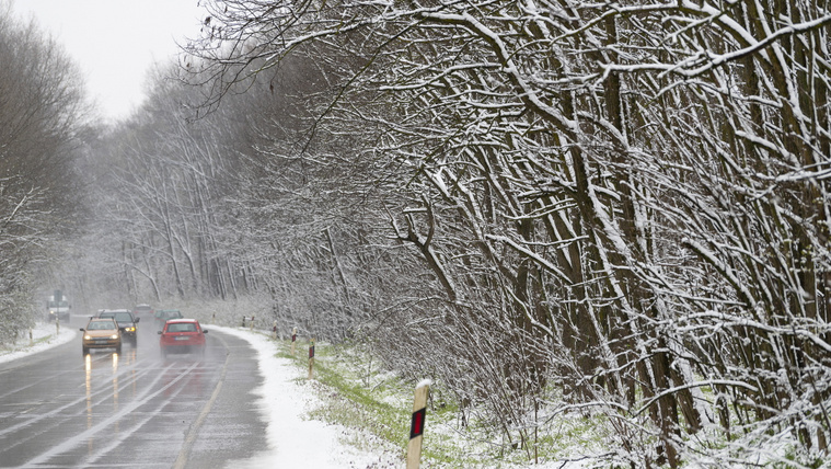 Autók közlekednek hóesésben Nyíregyházán a Sóstói úton 2023. április 6-án