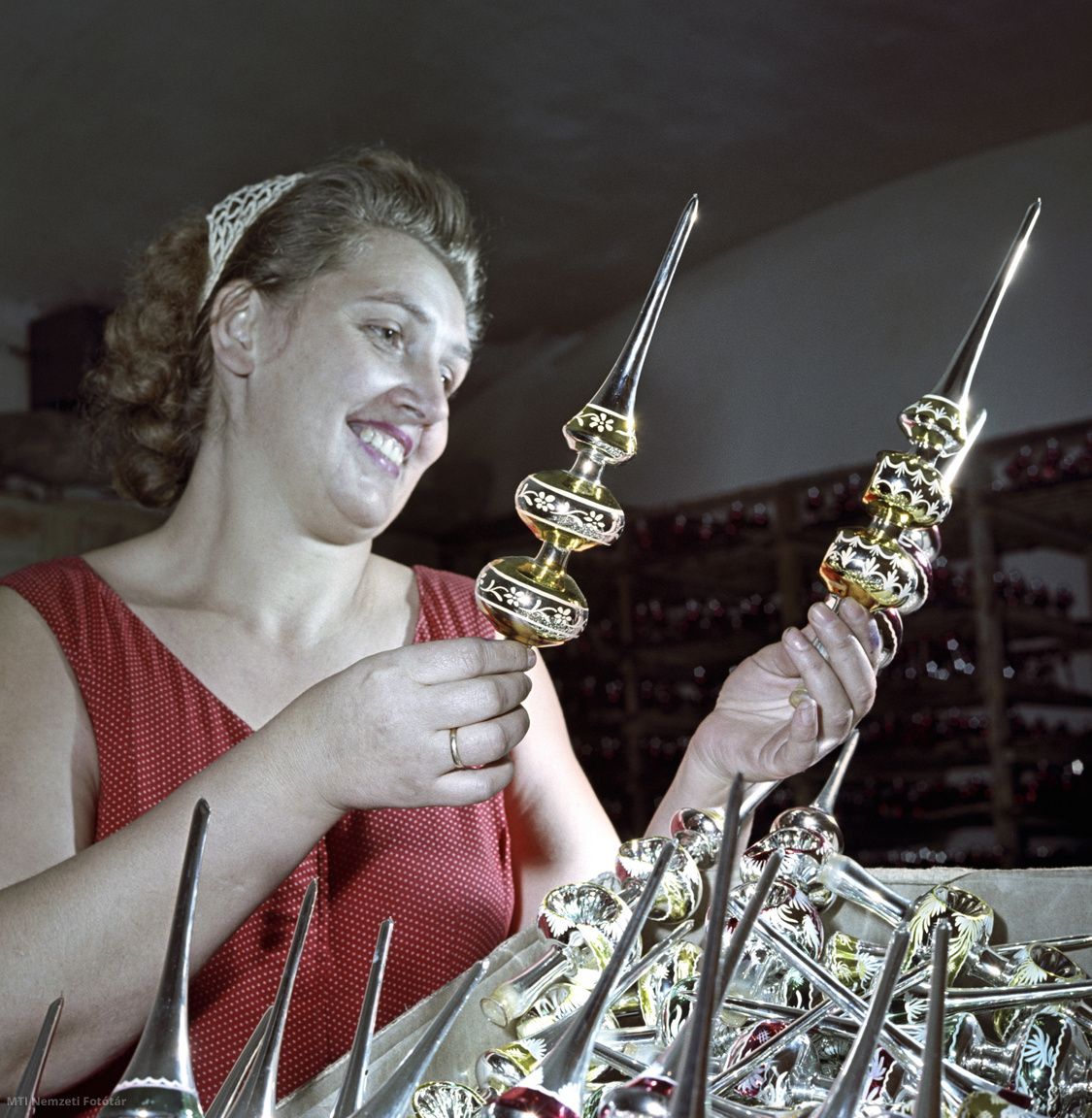 1958. november 5. Az elkészült, a karácsonyfára kerülő üveg csúcsdíszek minőségét ellenőrzi egy dolgozó. A felvétel készítésének pontos helye ismeretlen.