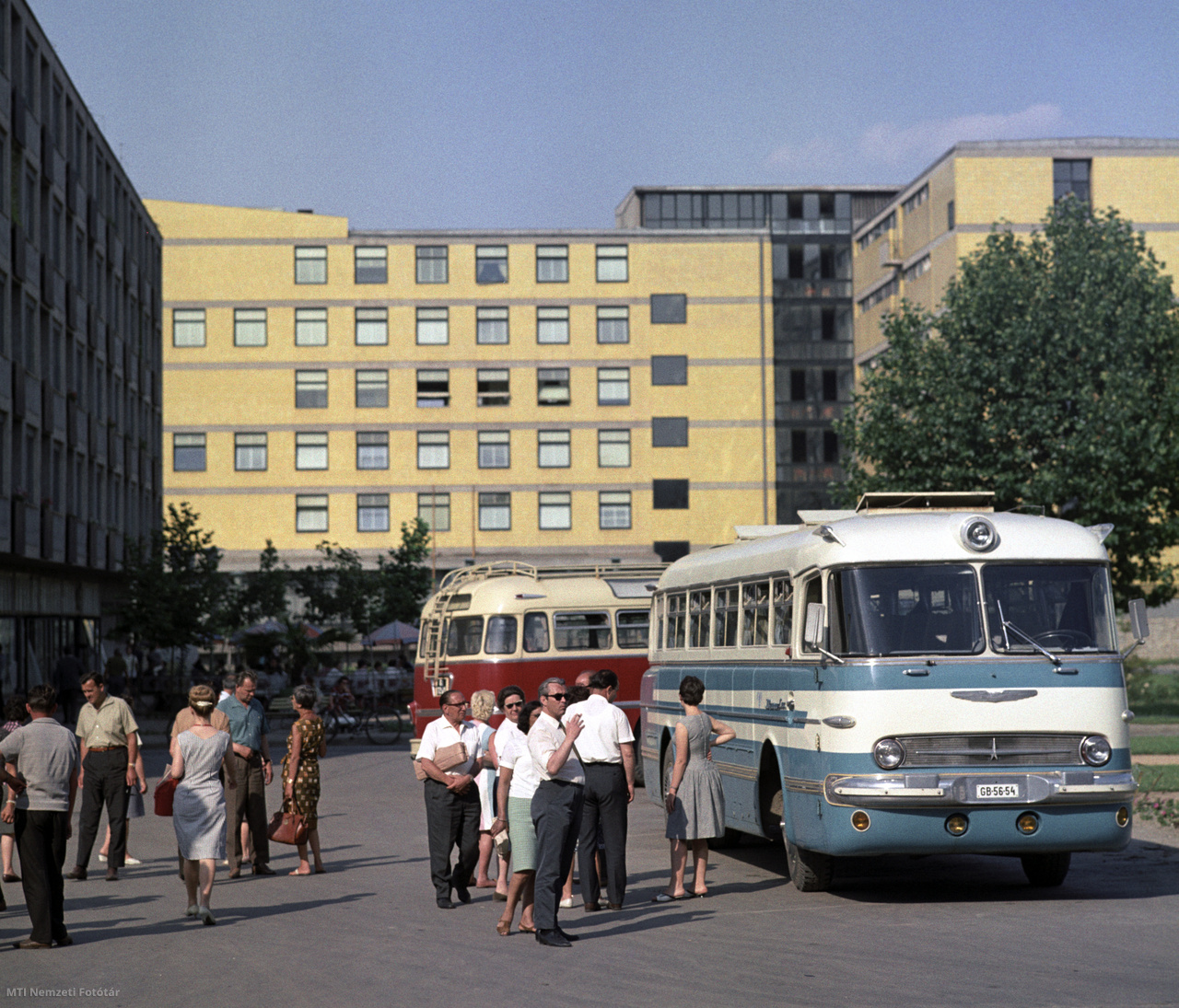 Dunaújváros, 1966. június 24. Turistákat szállító Ikarus autóbuszok a Magyar Dolgozók Pártjának Központi Vezetősége 1949 végén hozott döntése alapján a Duna folyó mellett létrehozott nehézipari településen, a Vasmű úton. A háttérben a tizenkét ápolási egységgel, ötszázötvenöt ággyal, 1965-ben átadott új kórház