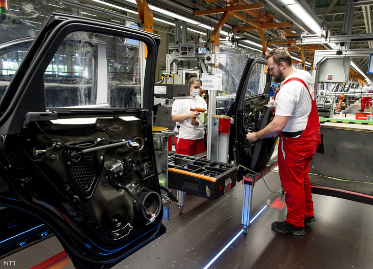 Dolgozók autók ajtaját szerelik össze a győri Audi-gyárban 2020. április 27-án