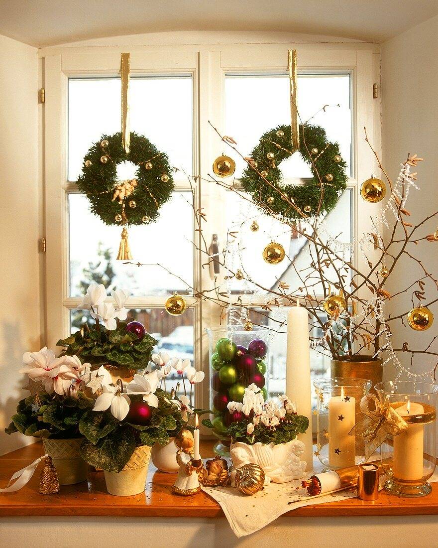 A fenyőkoszorúk nemcsak az asztalon, hanem az ablakban is remekül mutatnak. Dekorálhatod őket karácsonyfa díszekkel és selyemszalaggal is, amik rögzítésre is tökéletesek.