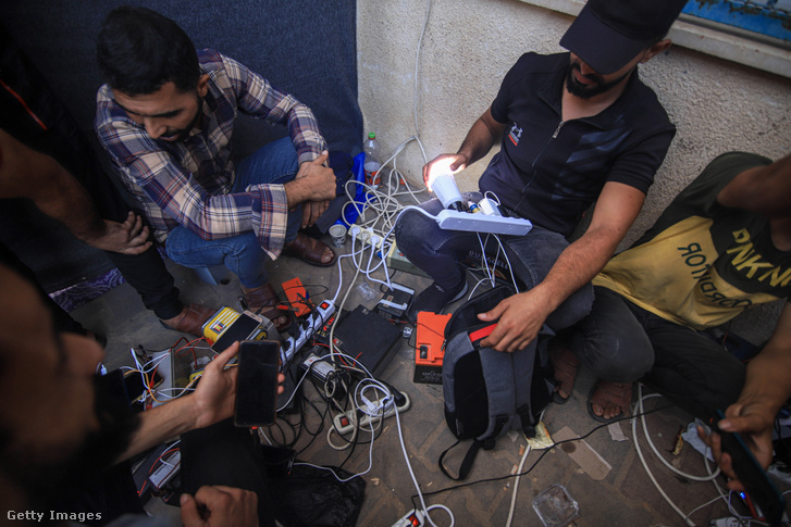 Palesztinok hordozható töltőállomásokon töltik mobiltelefonjaikat és akkumulátoraikat Khan Younis Gaza nyugati részén, 2023. október 31-én