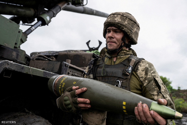 Az ukrán 55. Külön Tüzérdandár egy tagja egy Caesar önjáró tarackhoz való lövedéket visz Avgyijivka város közelében, Donyeck régióban 2023. május 31-én