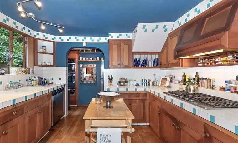 Szintén a földszinten található a hatalmas méretű, kék színű falakkal tarkított konyha, amelynek a közepén egy konyhasziget található.