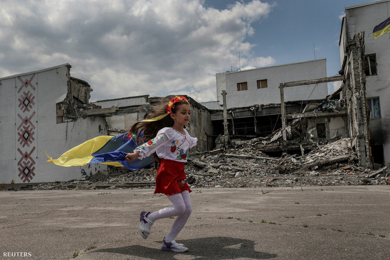 Egy lány fut a helyi Kultúrpalota előtt, amelyet egy orosz katonai csapás rombolt le  Derhachi városában, Harkiv régióban Ukrajnában 2023