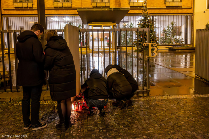 Emberek gyertyákat gyújtanak a Károly Egyetem főépülete előtt az egyik prágai épületben történt lövöldözést követően december 21-én