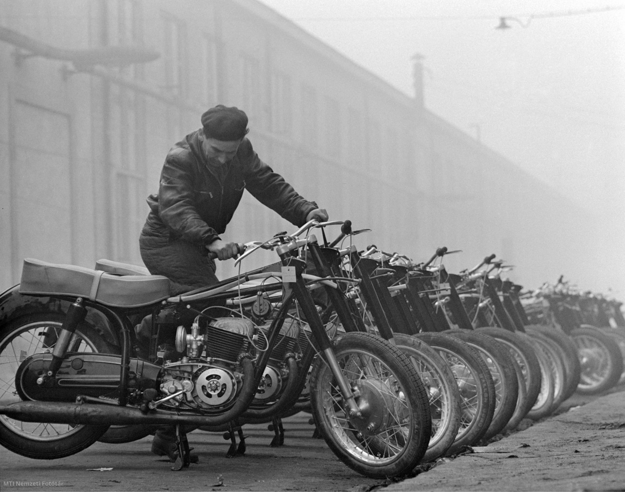 Budapest, 1959. január 2. Hack Károly minőségi ellenőr az újonnan gyártott, átadáshoz előkészített Pannónia TLF motorkerékpárok egyikét indítja be a Csepel Vas- és Fémművekben