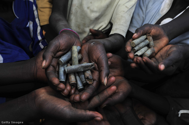 Szudáni gyerekek megmutatják a földről összeszedett lőszereket. (Fotó: Raul Touzon / Getty Images Hungary)