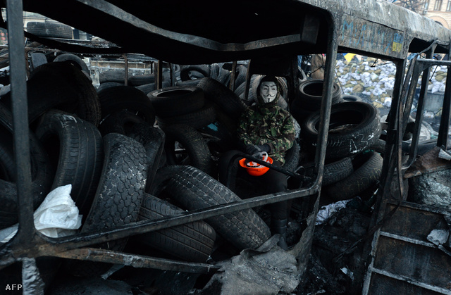 Ukrán tüntető egy kiégett busz roncsain